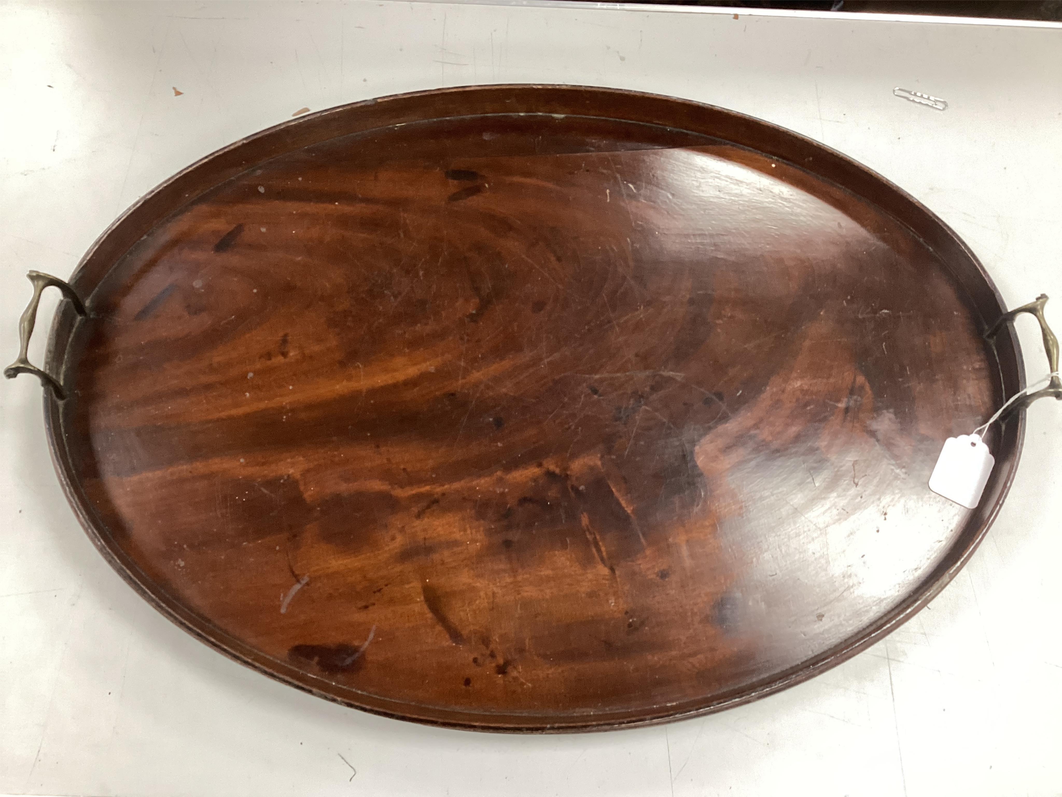 A Georgian oval mahogany two handled tea tray, width 73cm, depth 52cm. Condition poor, warped